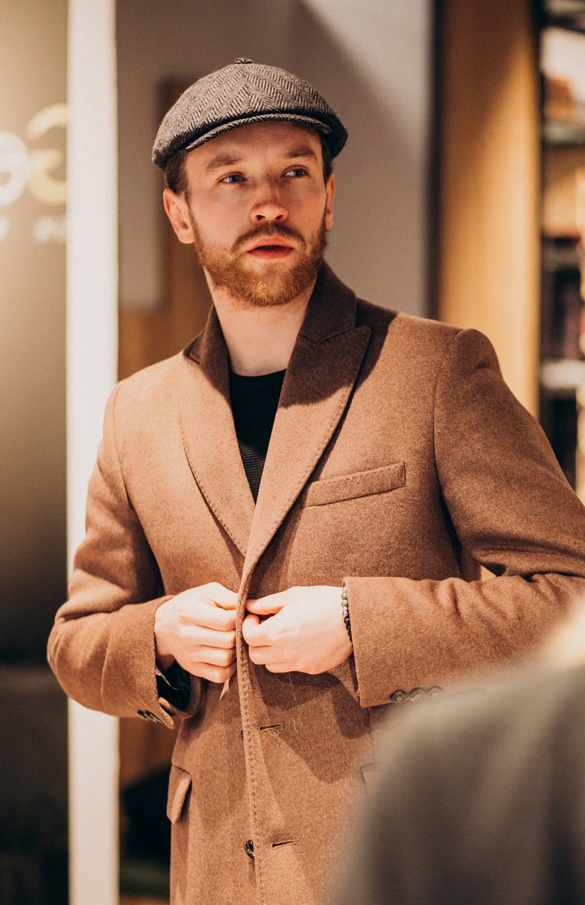 Young handsome man choosing hat at the shop